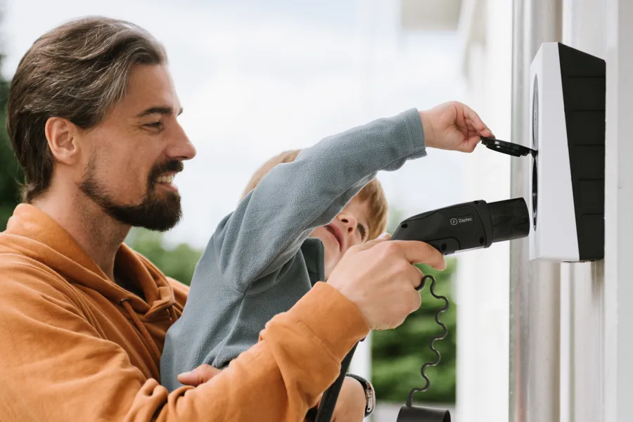 Mand og barn der oplader elbil 