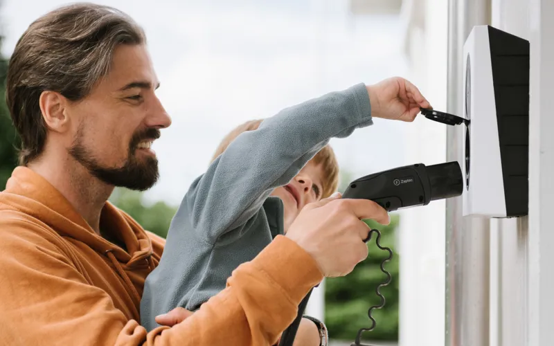 Mand og barn der oplader elbil